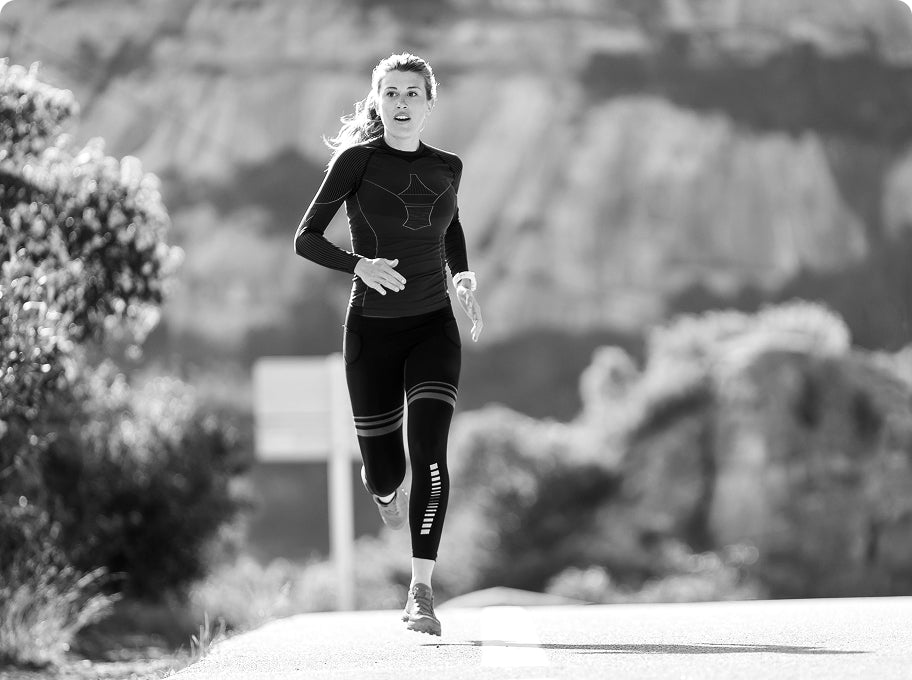 Woman running on a trail with a scenic background
