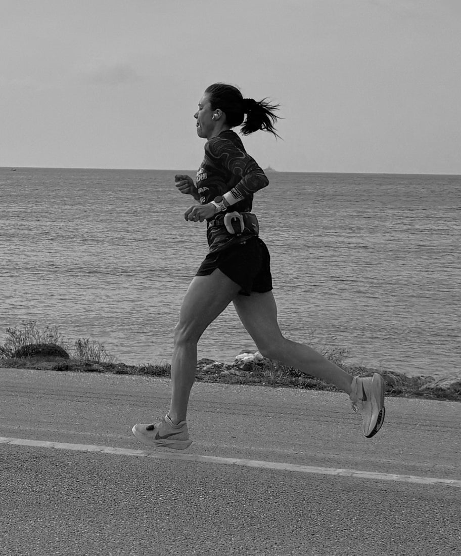 Person running on a road by the sea